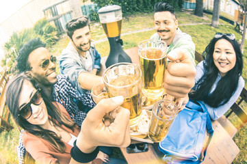 Multiracial group of happy friends millennials eating and toasting beer at garden barbecue party - Multiethnic hangout concept with young people enjoying picnic time together - Warm vintage filter