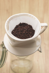 Drip coffee with paper filter tool on wood background