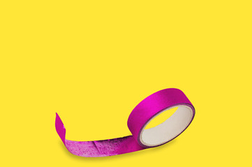 Roll of violet sticky tape on yellow background with copy space for your text