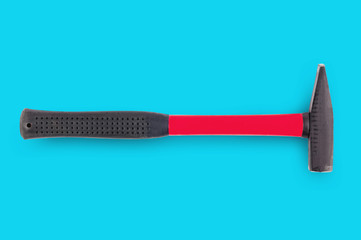 Single metal hammer with red and black rubber handle in center on blue background