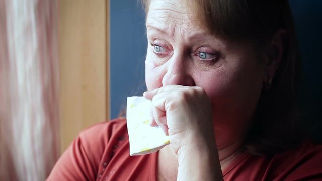 Elderly woman crying wiping her tears with a handkerchief