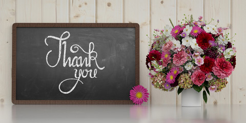 Thank you Text auf Tafel neben Blumen