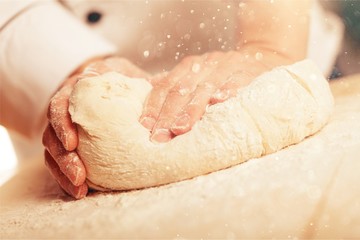 Woman's hands knead the dough close up