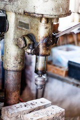 Metal industry stand with drill machine. Home workshop with hard tools on the metal stand. Old rusty hand tool drill machine on the metal stand