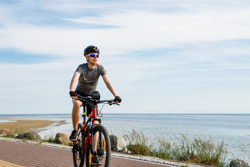 Young man biking at seaside