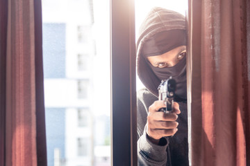 Bangerous masked burglar with crowbar breaking into a victim's home doo,Carry a gun to rob
