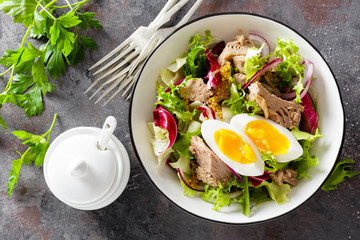 Diet food tuna salad with boiled egg, canned fish, onion and green lettuce top view