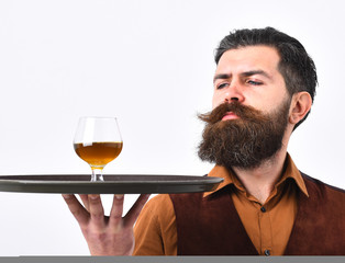 Waiter in vintage vest with whiskey or scotch on tray.