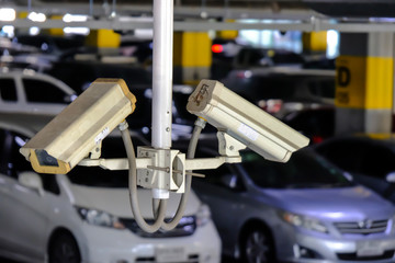 2 CCTV or Close Circuit Television are monitor and record cars in parking lot of shopping mall to...
