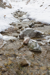 Fototapeta premium small frozen creek in a winter mountain landscape