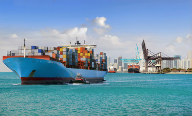 Large cargo ship with many shipping containers sailing from port 
