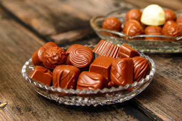Chocolate candies in crystal bowl on old vintage rustic table