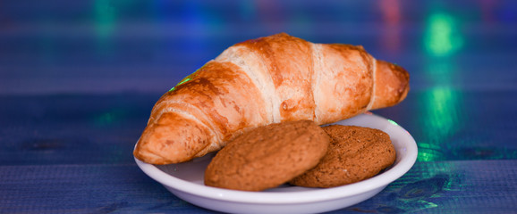 Treats for Santa concept. What do kids around world leave for Santa. Croissant and oat cookies on white plate. Winter holiday tradition. Sweets for Santa Claus and his helpers. Santa treats recipe