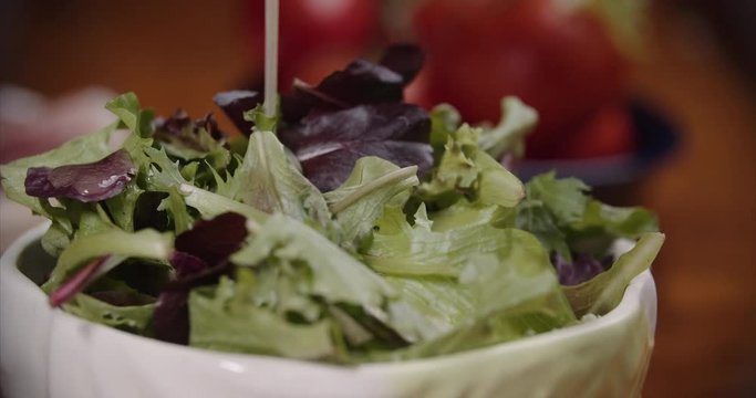 Pouring Vinaigrette Over A Mixed Green Salad. Glamor Shots Of Fresh Food