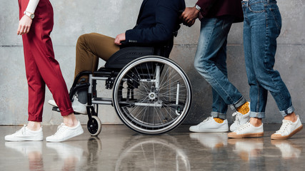 cropped view of people rolling man in wheelchair in waiting hall - Powered by Adobe
