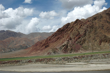 Tibetan brown mountains against the blue sky and white clouds, China