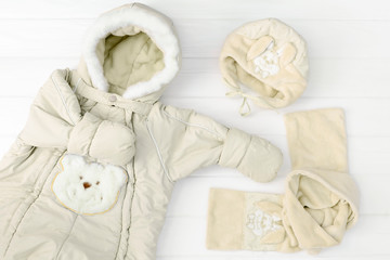 Obraz na płótnie Canvas Autumn or winter fashion outfit. Baby girl beige set of clothing on the white background.