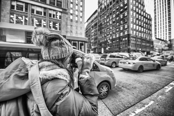 Female photographer taking pictures of New York Cabs in winter