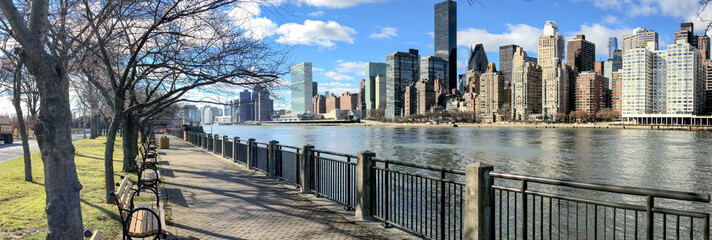 Panoramic view of Midtown Manhattan and East River from Roosevelt Island on a sunny day, New York...