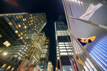 Downtown Manhattan skyscrapers, night skyward view from street level