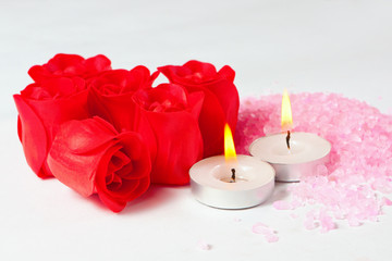 Fototapeta na wymiar rosebud soap, sea salt and candles for relaxing in the bathroom