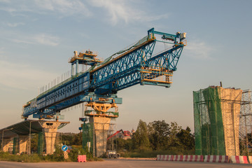 Fototapeta na wymiar Construction crane and girder of bridge construction site.New expressway construction site and equipment.