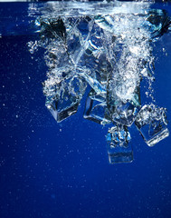 Ice cubes falling into the water