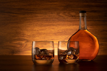 Whiskey with ice on wooden background. Rocks whiskey on the table