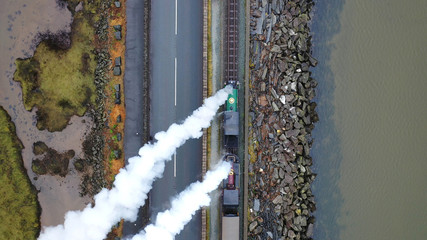 Aerial view of a vintage steam engine train with puffing smoke