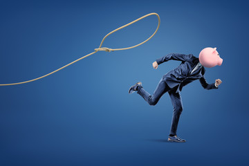 Businessman with piggy bank head running from loop on the blue background