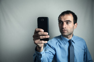 Caucasian businessman showing his smartphone.