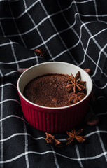 Chocolate fondant on black towel with cocoa beans on dark background, close up