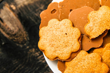 Cookies with honey and chocolate on white ceramic plate. Wooden rustic vintage table.