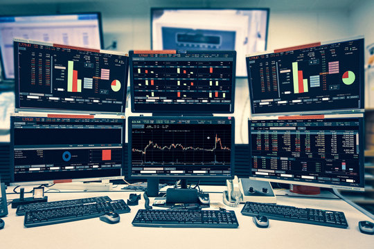Display of Stock market quotes and chart in monitor computer room with business office equipments .business and money concept, panorama photo