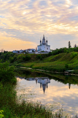 Obraz premium Beautiful panoramic view of Suzdal in summer at sunrise. the church and its reflection in the river in Suzdal. Suzdal is a famous tourist attraction and part of the Golden Ring of Russia.