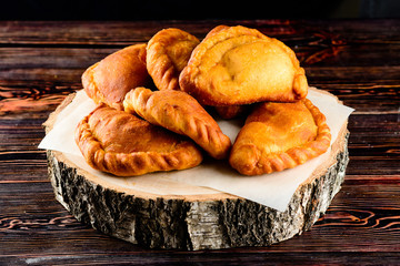 Fried homemade pies on a wooden background in rustic style © smspsy