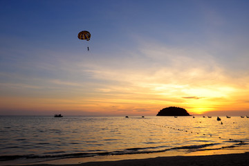 Fototapeta na wymiar Silhouette of Parasailing at Kata beach with sunset, Phuket, Thailand.