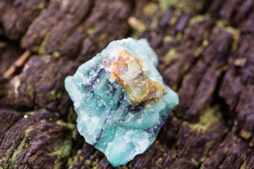 Raw emerald on natural wooden background