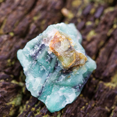 Raw emerald on natural wooden background