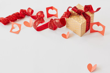Gift box with red ribbon and red paper hearts on white background. Valentine's day, love, holiday present concept