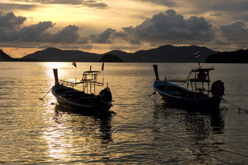 Silhouette of Long tail boats at sunset beach. Panwa Cape, Phuket Province, Thailand.