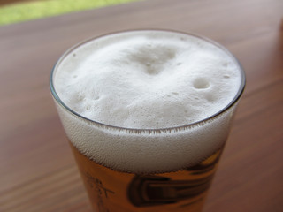 Glass of beer on the table . Beer foam closeup