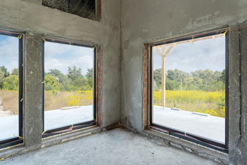 Fototapeta na wymiar Big windows in new unfinished brick house