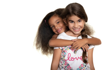 Cute hispanic and african-american small girls hugging