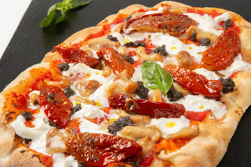 Pizza italiana con pomodoro, basilico, funghi e mozzarella in primo piano