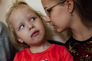 little girl attentively listens to her older sister