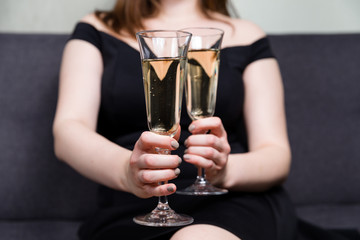 Valentines day romance, beautiful woman holding champagne glasses in hands,close up.