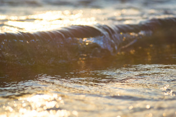 pebble stones on the sea beach, the rolling waves of the sea with foam