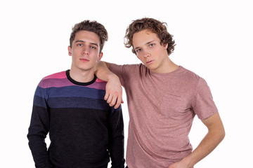 Two happy friends in casual wear standing and laughing together. Best friends enjoying isolated over white background