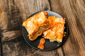 Baklava - homemade pie with walnuts on old wooden table